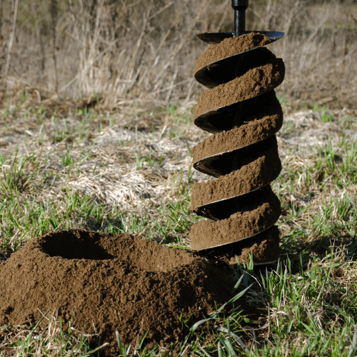 Clay soil on the flutes of post hole auger