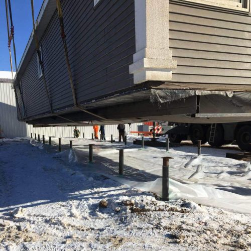 Lifting a manufactured home onto screw piles